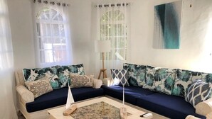 A living room with two sofas, a coffee table, and a lamp. - Exclusive Luxury Getaway: 6 BRM Tropical Villa, Just 5 Minutes from Beaches (Sosúa)