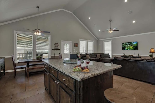 A spacious kitchen with a large island, dark wood cabinets, and a dining area with a table and chairs.