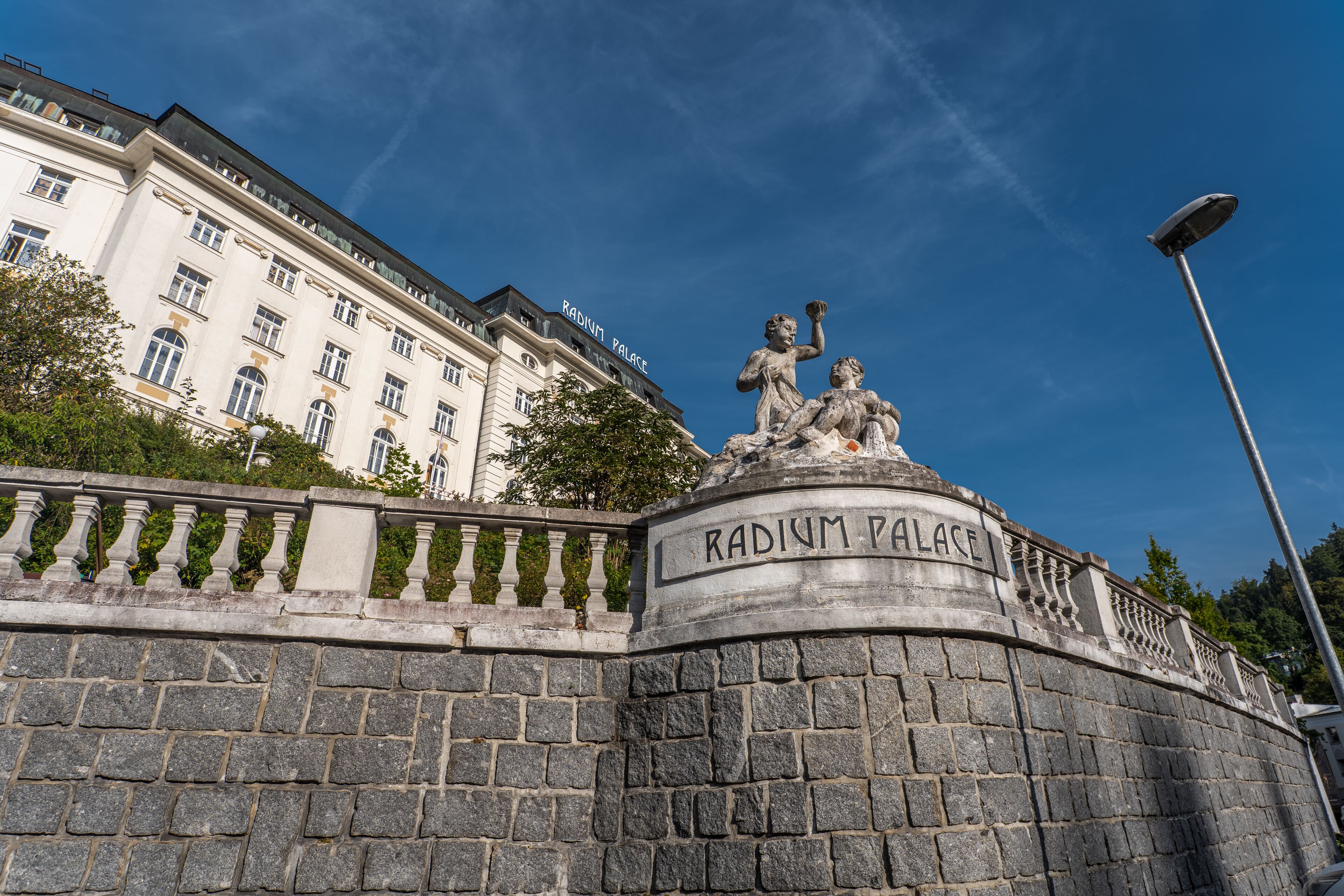 A stone wall with the inscription "Radium Palace" and a statue of two figures.