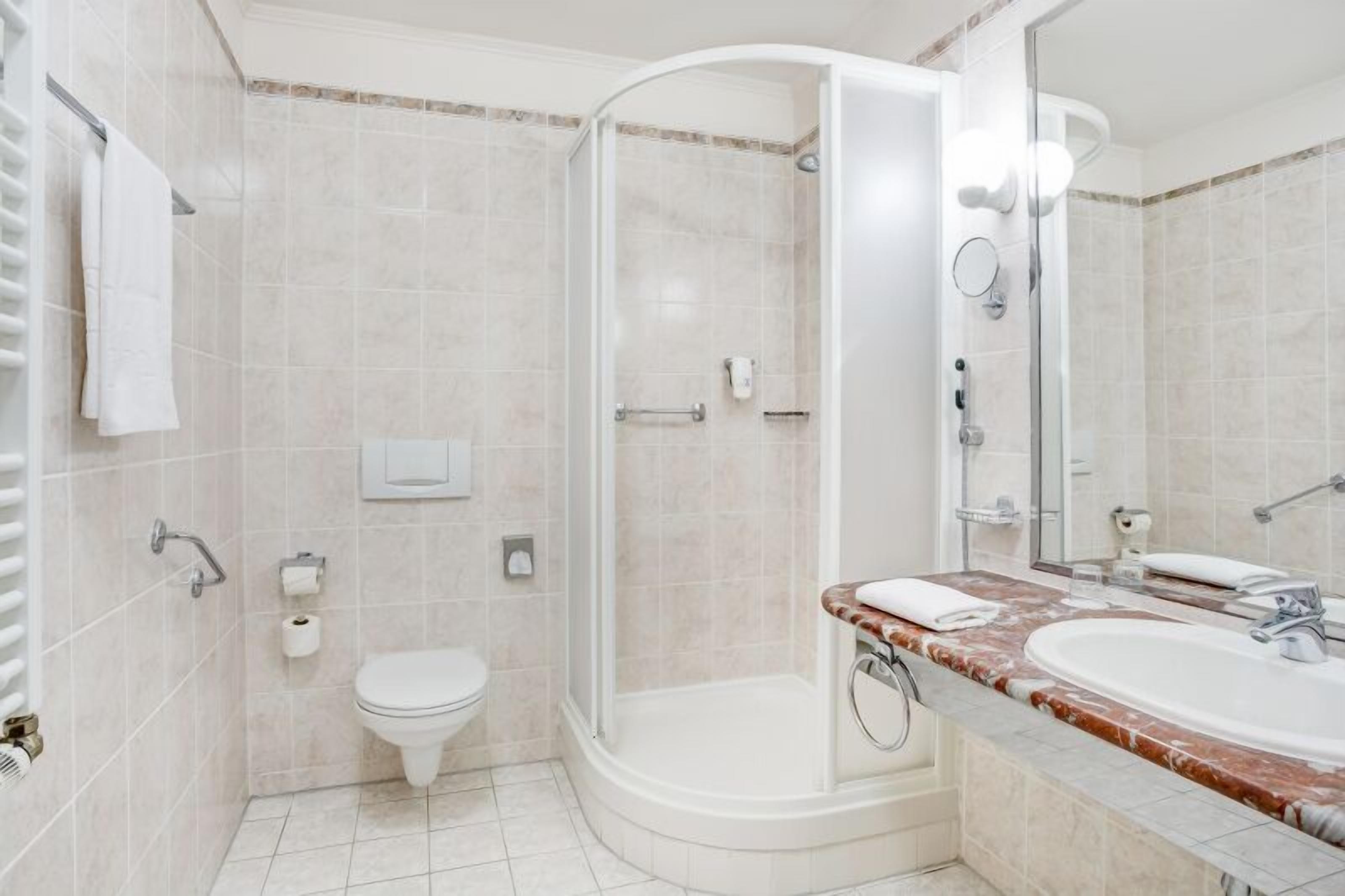 A modern bathroom with a shower, toilet, and sink.