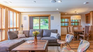 A spacious living room with a sectional sofa, a coffee table, and a colorful armchair. - JHRL - Nez Perce A2 - Beautifully renovated, 1st floor condo (Teton Village)