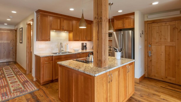 A kitchen with wooden cabinets, granite countertops, stainless steel appliances, and pendant lighting. - JHRL - Nez Perce A2 - Beautifully renovated, 1st floor condo (Teton Village)