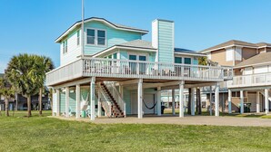 A two-story house with a balcony and a covered porch. - Private Beachside Home, Perfect for Families, Updated Interior & Near Beach (Galveston)