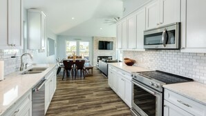 A modern kitchen with white cabinets, a built-in microwave, and a large oven. - Private Beachside Home, Perfect for Families, Updated Interior & Near Beach (Galveston)