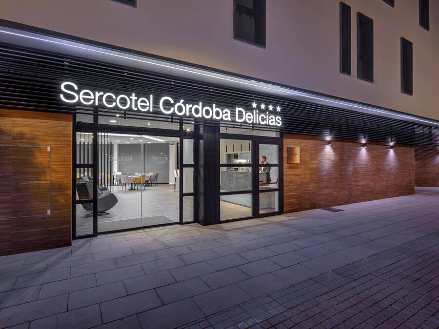 A modern hotel entrance with a sign reading "Sercotel Córdoba Delicias".