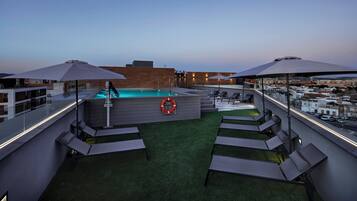 Una piscina al aire libre de temporada, sombrillas, tumbonas