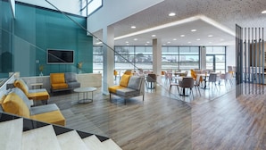 Ein modernes Interieur mit einer Sitzecke, einem Empfangsbereich und einer Treppe.