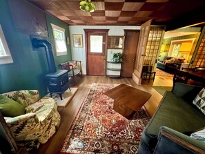 A living room with a piano, a patterned sofa, a coffee table, and a patterned rug.