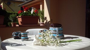 Ein runder, weißer Tisch mit Blumen und Keramiktassen.