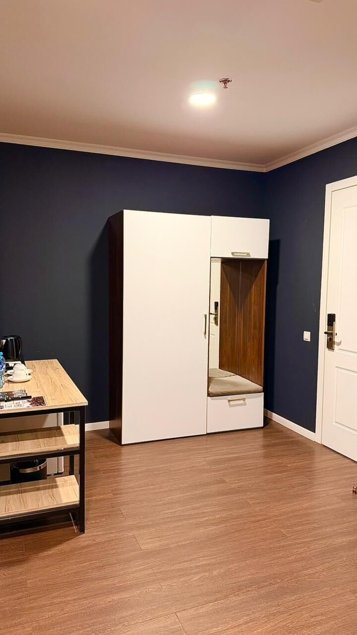 Habitació amb armari, taula amb objectes i una porta.