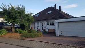 A single-story house with a garage, a front porch, and a tree in the yard. - Ferienwohnung "Gast4" (Weikersheim)