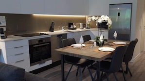 Una cocina moderna con comedor, que incluye horno empotrado, microondas y lavaplatos.