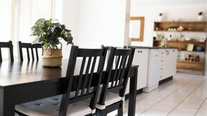 Una cucina moderna con tavolo, sedie e una pianta in vaso.