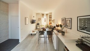 Une cuisine moderne avec un coin repas, un lave-linge et une petite table avec des chaises.