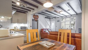 A kitchen with a dining table, chairs, a microwave, and a coffee maker. - 5 Ivy Yard (Whitby)
