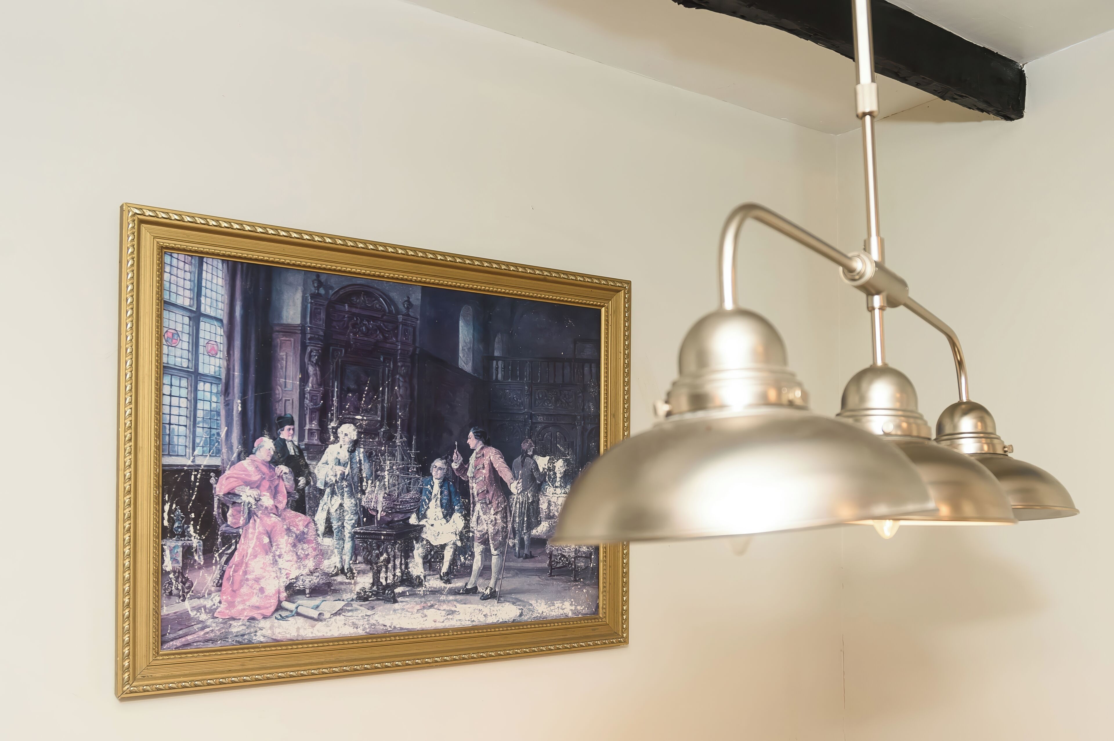 A painting of a historical scene with figures in period clothing, a classic chandelier, and a white wall.