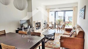 Una sala moderna con comedor, un sofá y una chimenea.