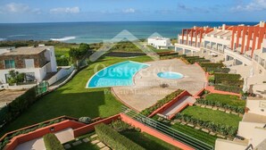 Un resort con piscina, vistas al océano y un jardín bien cuidado.