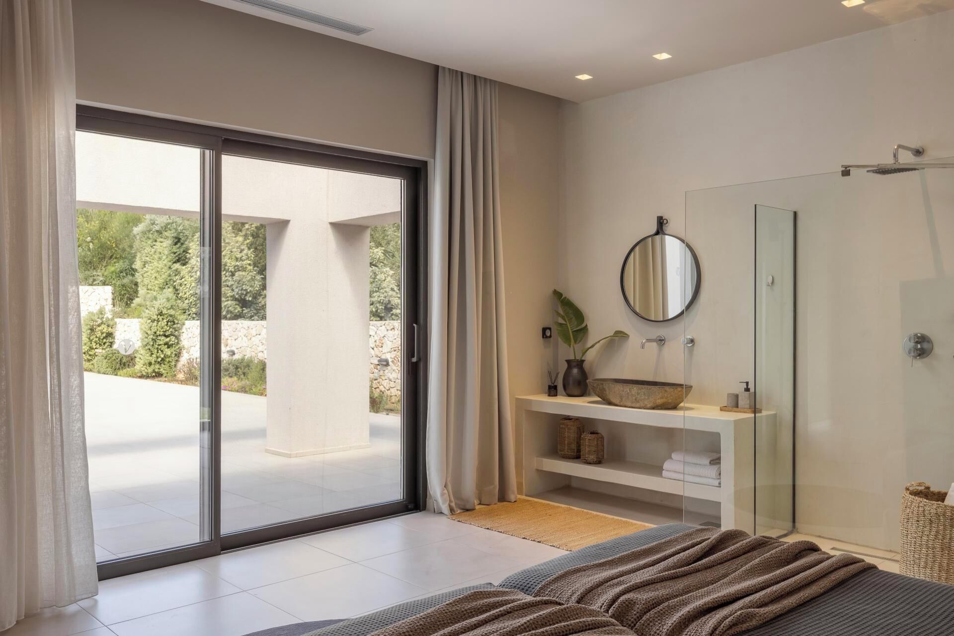 Une salle de bain moderne avec une douche à parois de verre, un grand miroir et un lavabo avec un receveur en forme de cuvette.