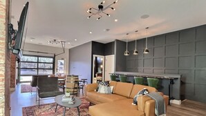 Un salon moderne avec un canapé d’angle, une table basse et un tapis à motifs.
