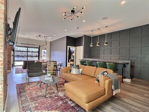 A modern living room with a sectional sofa, a coffee table, and a patterned rug.