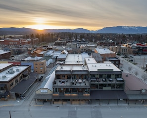 A downtown area with a mix of commercial and residential buildings, including a hotel with a flat roof and outdoor seating area.
