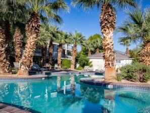 A swimming pool surrounded by palm trees and a building in the background. - Amazing view, pools/hot tubs/waterslide, trails. Las Palmas resort! Sleeps 10 (St. George)