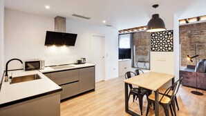 Una cocina moderna con microondas integrado, un fregadero y una zona de comedor con mesa y sillas.