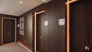 Un pasillo con tres puertas de madera, cada una con un número.
