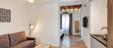 A modern apartment with a living room, kitchenette, and a bedroom.