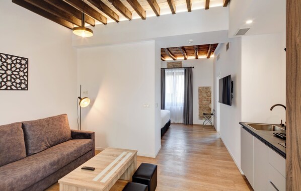 A modern apartment with a living room, kitchenette, and a bedroom. - Sercotel Granada Suites (Granada)