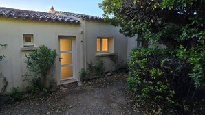 A building with a tiled roof, a door, and two windows.