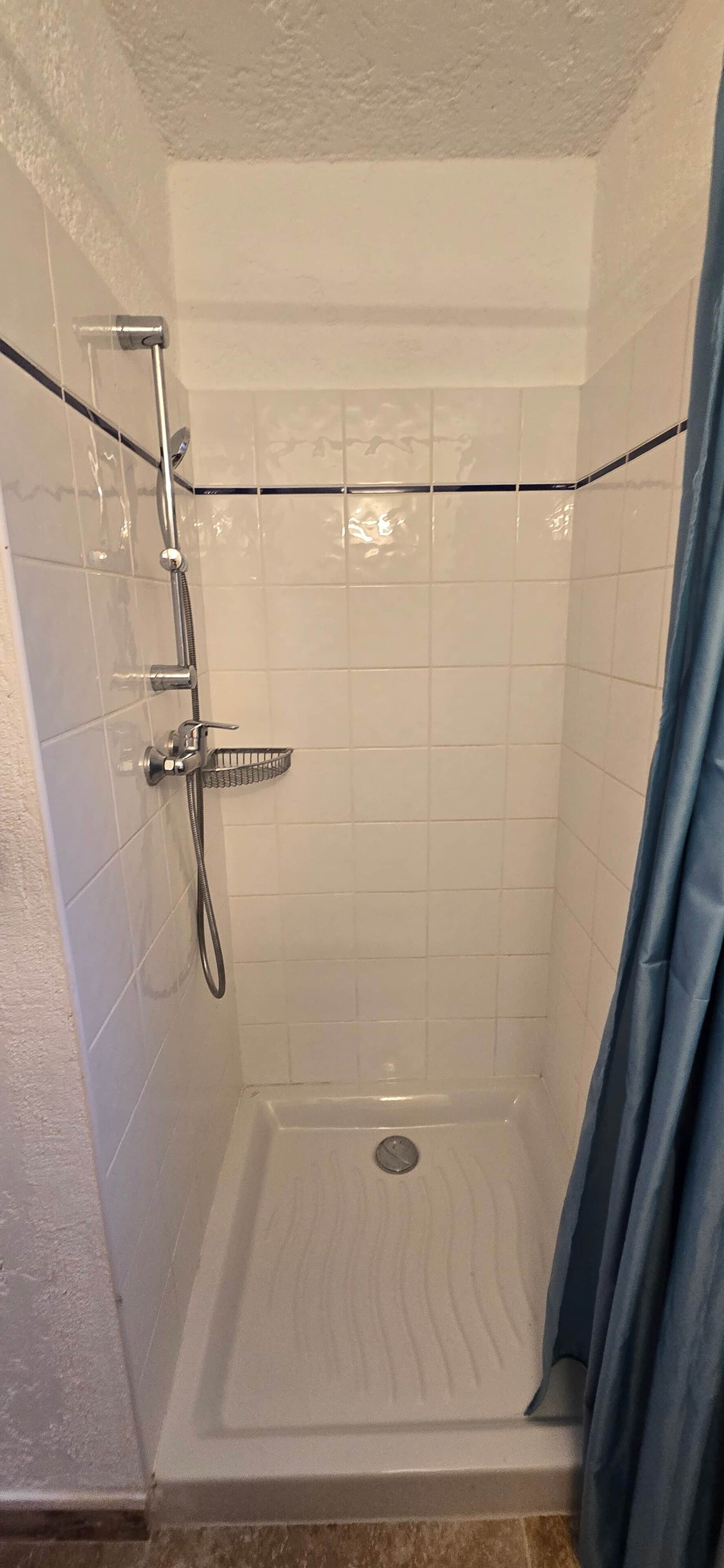 Ducha con cabezal de ducha de mano, grifo empotrado y regulador de ducha.