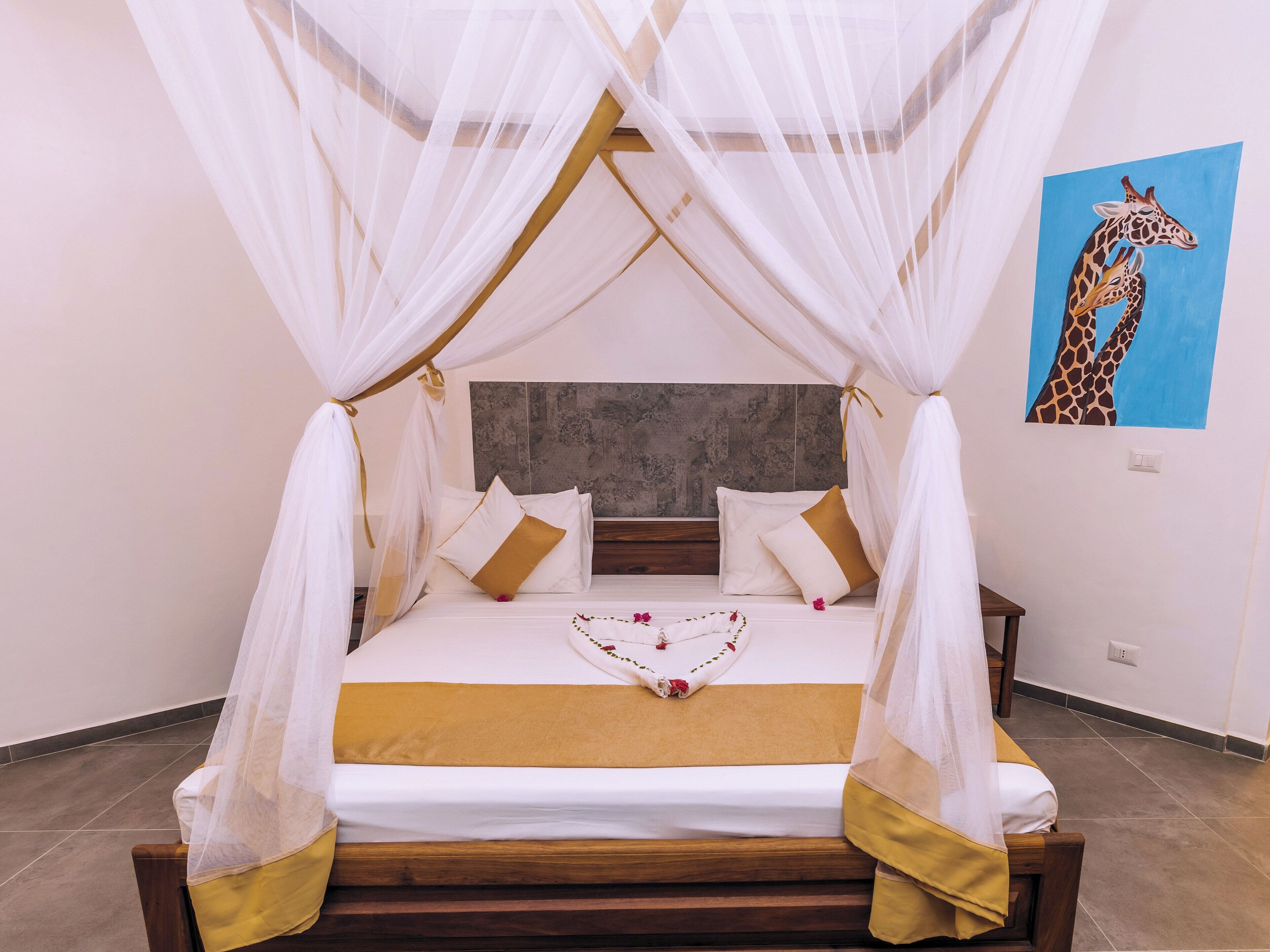 A bed with a canopy, pillows, and a decorative item on the bed.