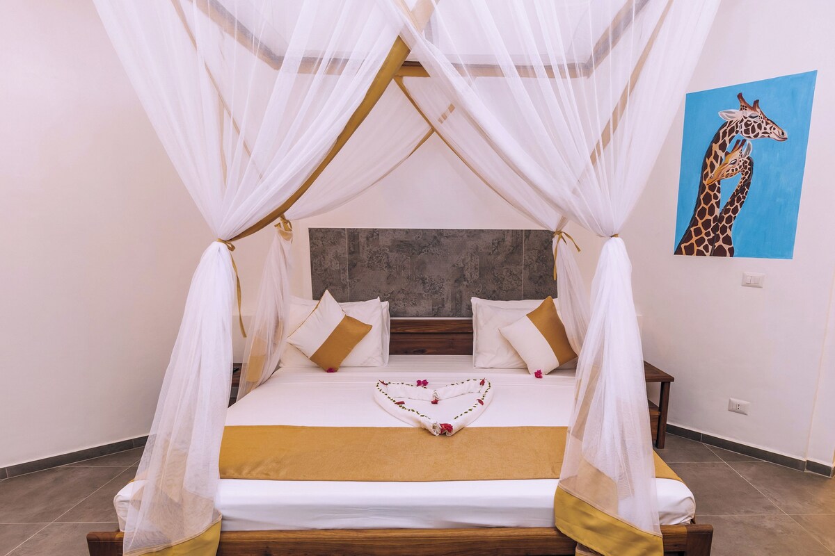 A bed with a canopy, pillows, and a decorative item on the bed.