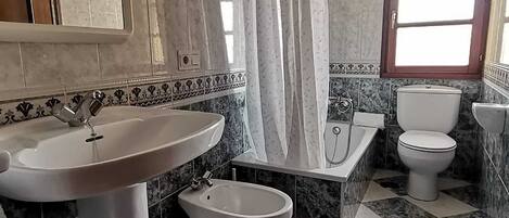 Bany amb rentamics, vàter, lavabo i banyera.