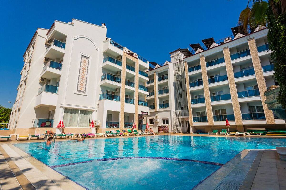 A hotel with a swimming pool, multiple balconies, and a modern architectural design.