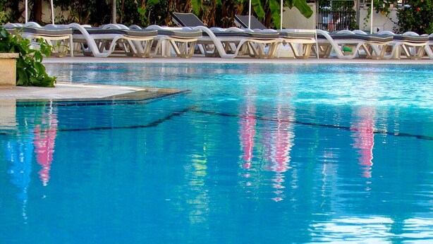 Ein klares Schwimmbecken mit Liegestühlen am Rand.