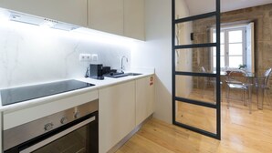 A modern kitchen with white cabinetry, a built-in oven, and a black countertop. - Modern Vitoria Getaway by LovelyStay (Porto)
