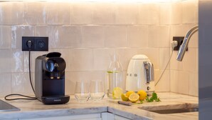 A kitchen with a coffee maker, a water dispenser, glasses, lemons, and a sink. - Luxurious Duplex with Unique View by LovelyStay (Porto)
