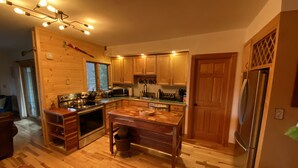 Una cocina moderna con armarios de madera, electrodomésticos de acero inoxidable y una isla central.