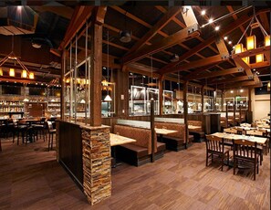 A restaurant interior with wooden beams, stone pillars, and a bar area. - Breck Peak 7 2bd/2Bth Ski-In-Out DREAM Unit! 4th Floor Max Views! (Breckenridge)