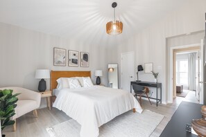 Una camera da letto moderna con un letto grande, comodini, una scrivania e una sedia.