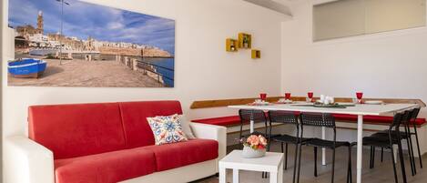 Relax in this stylish living area with a sofa, dining table, and side table.
