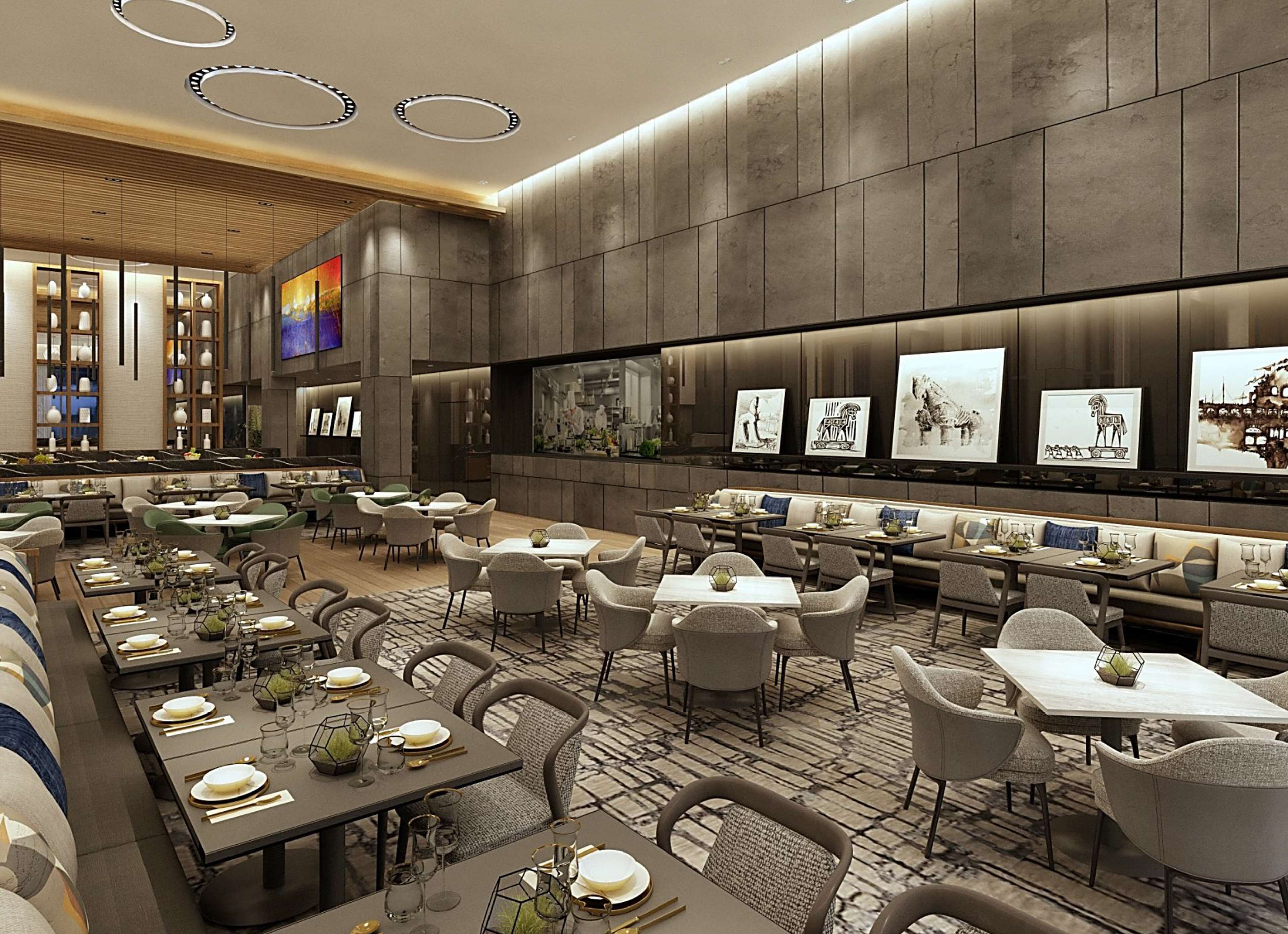 Un restaurant moderne doté de plusieurs espaces de restauration, notamment une grande table conviviale et plusieurs petites tables.