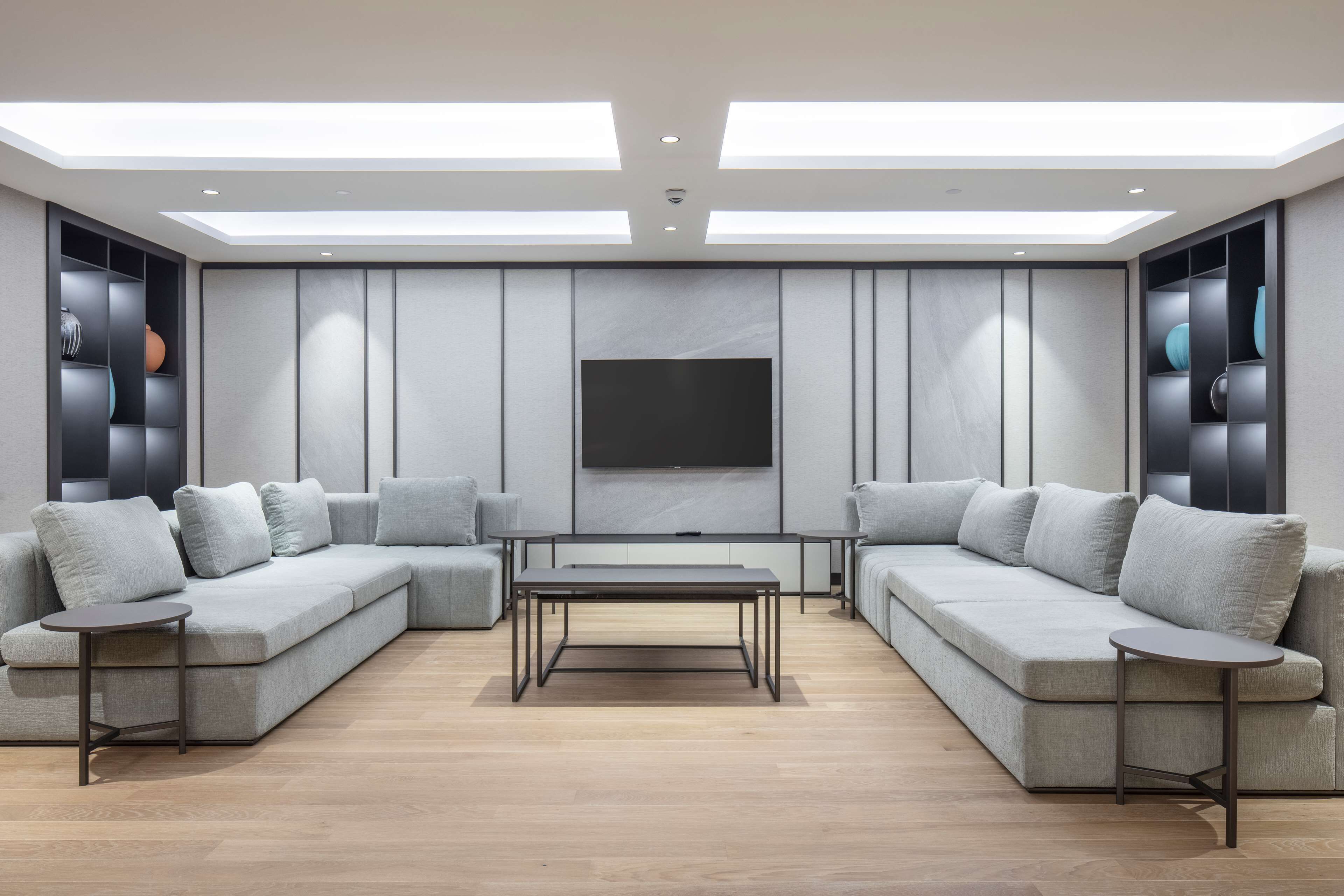 A modern living room with a sectional sofa, a coffee table, and built-in shelving.