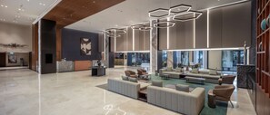 Relax in our spacious lobby, featuring a reception desk, comfortable seating, and a unique ceiling light fixture.