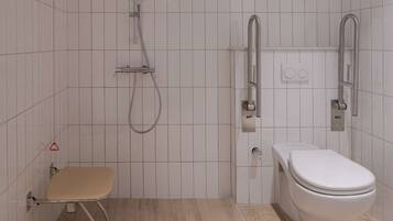 Ett modernt badrum med toalett, dusch och en bänk.