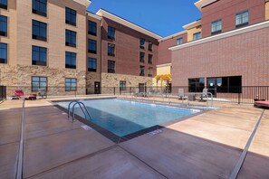 A swimming pool with a metal ladder, surrounded by a brick building with multiple windows and a stone facade. - Homewood Suites by Hilton Oklahoma City Quail Springs (Oklahoma City)