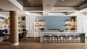 A modern kitchen with a central island, bar stools, and a herringbone-patterned backsplash. - Shore House at The Del, LXR Hotels & Resorts (Coronado)